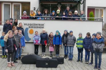 Das Bild zeigt die Schülerinnen und Schüler der Klasse 5a bei ihrem Besuch vor dem Bürgerheim mit den verantwortlichen Lehrkräften Birgitta Möckel und Helmut Radeck. 