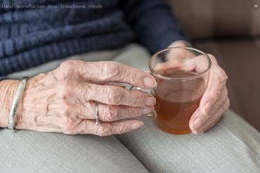 Das Bild zeigt eine Oma beim Teetrinken.