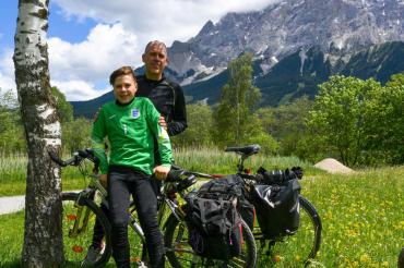 Das Bild zeigt zwei Radfahrer in den Alpen.