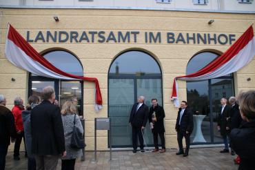 Hermann Faul, Stefan Rößle, Ulrich Lange und Stadträte enthüllen Schriftzug Landratsamt im Bahnhof