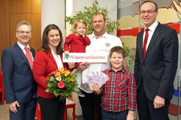 Sparkassendirektor Johann Natzer und Geschäftsstellenleiter Alexander Gruber gratulierten der jungen Familie mit einem Blumenstrauß und 20 Scheinen je Fünfhundert Euro.