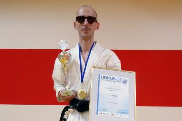 Rene Steinhübel im Keikogi mit Pokal und Urkunde