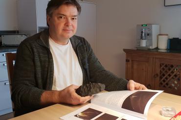 Mann mit Meteorit am Küchentisch