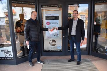 Übergabe des ersten Päckchens durch Jo Tomaschewski (rechts) von der Top Parfümerie, an Robert Schuck, Fahrdienstkoordinator des Caritasverbands.