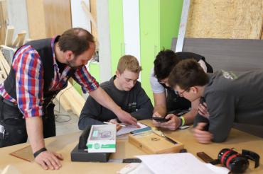 Das Bild zeigt Auszubildende der Schreinerei Stark in Auhausen die zusammen mit ihrem Lehrmeister ein Projekt erarbeiten.