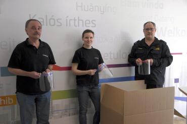 Übergabe der Gesichtsschilder von Werner Müller und Regina Rebele an den Katastrophenschutz-Koordinator Heinz Mayr.