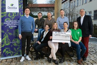 Geschäftsführung und Mitarbeiter von Destilla mit Spendenscheck
