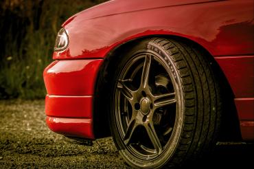 Linke Vorderseite eines roten Autos mit Alufelge