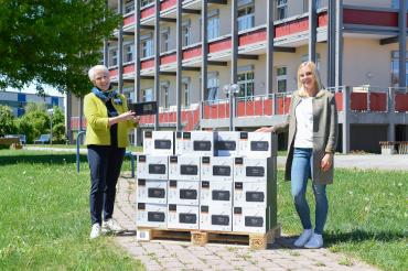 Zwei Frauen mit Palette voller Radios im Karton