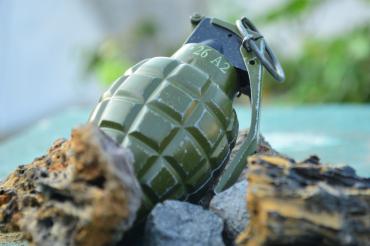 Handgranate auf dem Boden zwischen Steinen