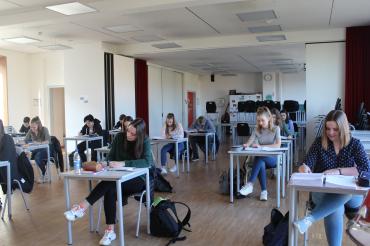 Schüler im Klassenzimmer an Einzeltischen. 