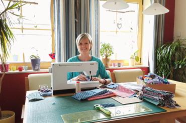 Das Bild zeigt Corina Karl an der Nähmaschine. 