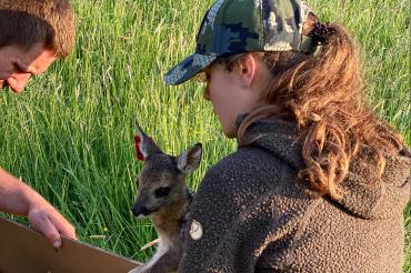 Frau mit Rehkitz im Arm