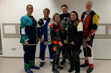 Sechs Sportschützen im Anzug