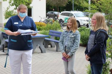 Altenpflegerin mit Mundschutz bekommt Briefe von zwei jungen Mädchen