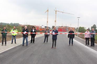 9 Personen durchschneiden Band über einer Straße