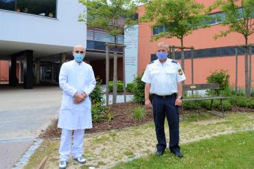 Das Bild zeigt (von links nach rechts):  Oberarzt Dr. Thomas Schmitt und Polizeihauptkommissar Thomas Schneid bei der Spendenübergabe vor dem Stiftungskrankenhaus. 