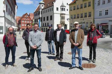 Sieben Personen stehen am Marktplatz in Nördlingen