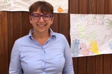 Claudia Riedelsheimer vor Wand mit Grußbotschaften