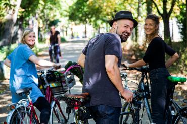 Personen mit Fahrrädern schauen in die Kamera
