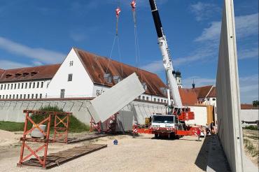 Auf der grünen Wiese vor der Anstalt baut das Staatliche Bauamt Augsburg am östlichen Ortsrand von Niederschönenfeld derzeit eine Torwache, ein Multifunktionsgebäude mit Wertstoffsammelstelle sowie ein Außenlager.