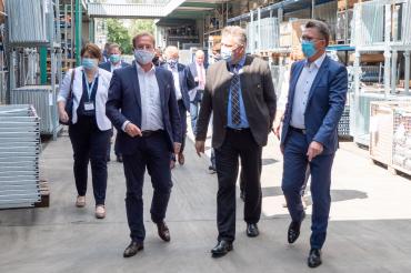 Personen mit Mundschutz erkunden Geda-Werk