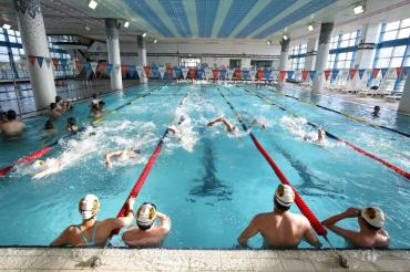 Menschen schwimmen in einem Hallenbad
