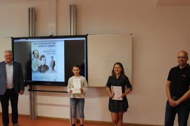 Zwei Männer und zwei Mädchen, Kinder mit Urkunden