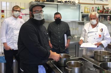 Vier Köche in der Küche, mit Masken