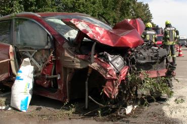 Zerstörtes rotes Auto auf Straße