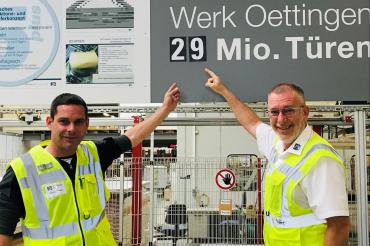 Zwei Herren in Warnwesten zeigen auf Zahl 29