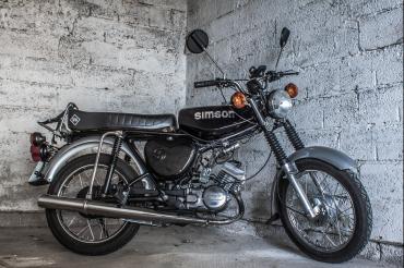 Moped vor grauer Wand