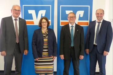 Eine Dame und drei Herren stehen vor RVB-Roll-ups