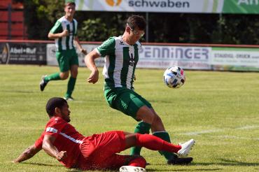 Zwei Fußballer im Zweikampf, einer grätscht