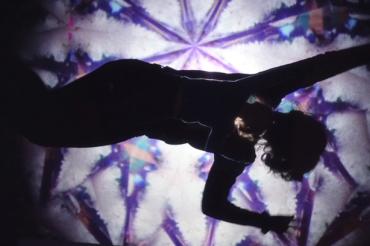 Das Bild zeigt eine Frau beim Malen mit Sand