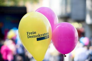 Drei Luftballons, zwei in magenta, einer gelb mit Aufdruck "Freie Demokraten FDP"