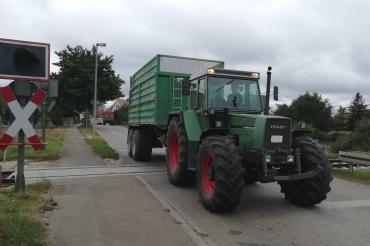Traktor mit Anhänger überquert Bahnübergang Dürrenzimmern