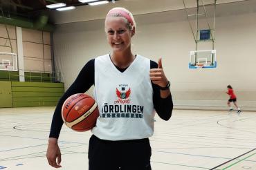 Baketballspielerin mit Ball in Turnhalle