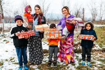 Das Bild zeigt eine Familie in Rumänien, die Weihnachtsgeschenke durch die Organisation Samaritan’s Purse bekommen hat.