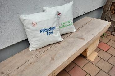 Zwei Kissen auf einer Holzbank