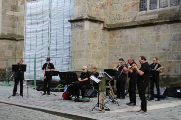 Das Bild zeigt die acht Musiker der Stadtjazzerey vor St Georg in Nördlingen.