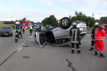 Rettungskräfte an Unfallort mit zwei Autos auf Straße