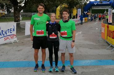 Zwei Läufer und eine Läuferin stehen auf einer Laufstrecke