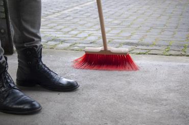 Straße wird mit Besen gekehrt