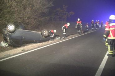 Verunglückter Pkw im Straßengraben, dabei Feuerwehrleute