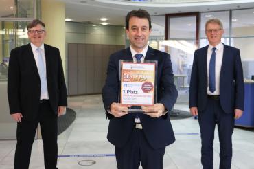 Paul Ritter, Michael Sandmaier und Bernhard Ströbele präsentieren Auszeichnung „Beste Bank vor Ort“