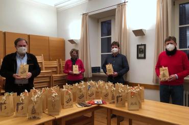 Vier Personen mit Maske und Geschenken