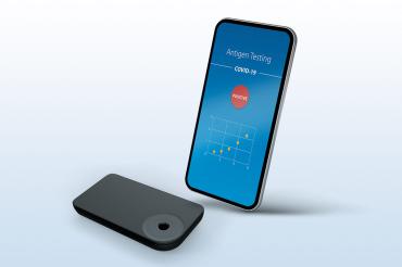 Smartphone und Corona-Testgerät