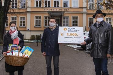 Kathrin Häffner, David Wittner, Helmut Kaumeier mit Spendenscheck und Bücherkorb