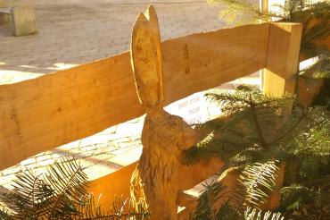 Hölzerne Hasenskulptur an einem Holzzeun